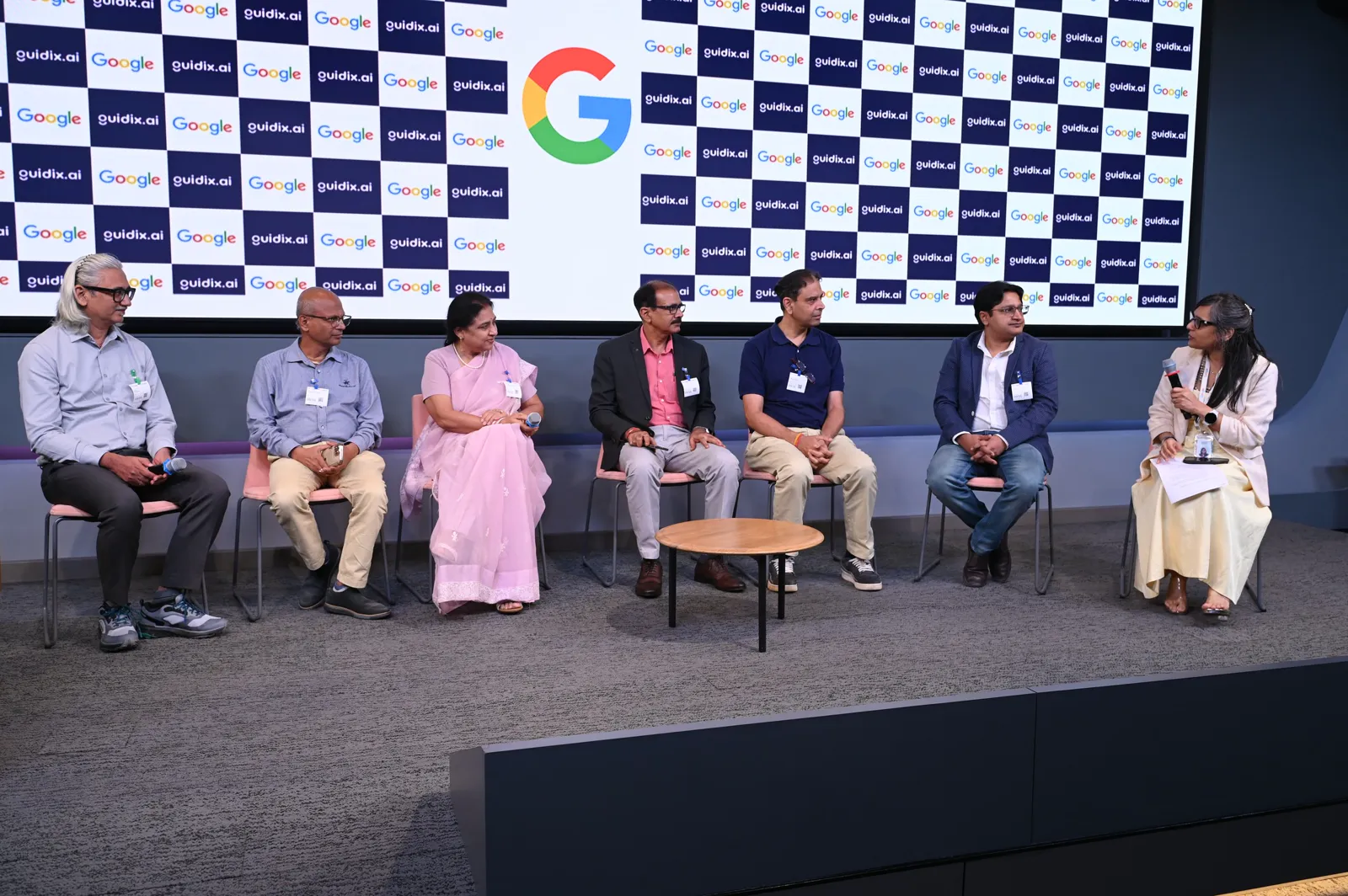 Seven university leaders seated on stage for the panel discussion